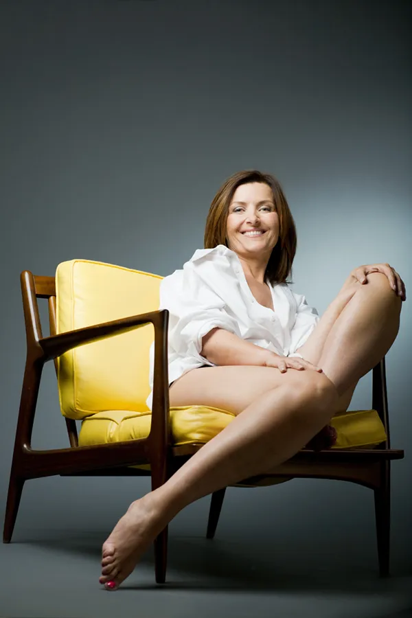 A middle-aged woman with bare, toned legs sitting in a chair. Get Endermologie for Cellulite Treatment from Dr. Hadi Michael Rassael at Millennium Wellness in Bethesda-Chevy Chase.