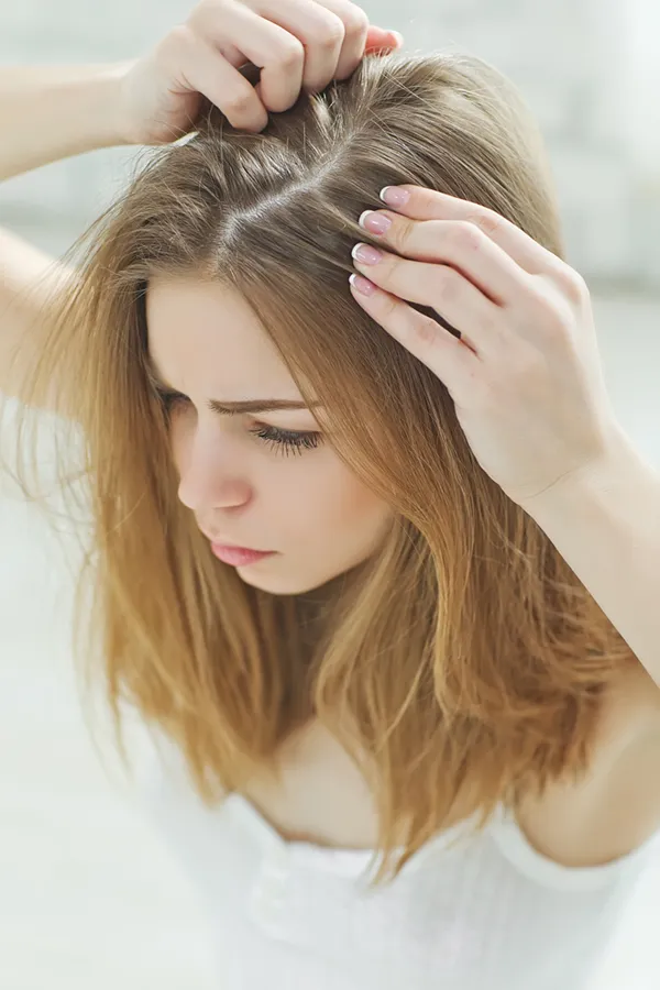 A woman looks at her scalp for thinning hair. Get FUT (Follicular Unit Transplantation) treatment from Dr. Hadi Michael Rassael at Millennium Wellness in Bethesda-Chevy Chase.