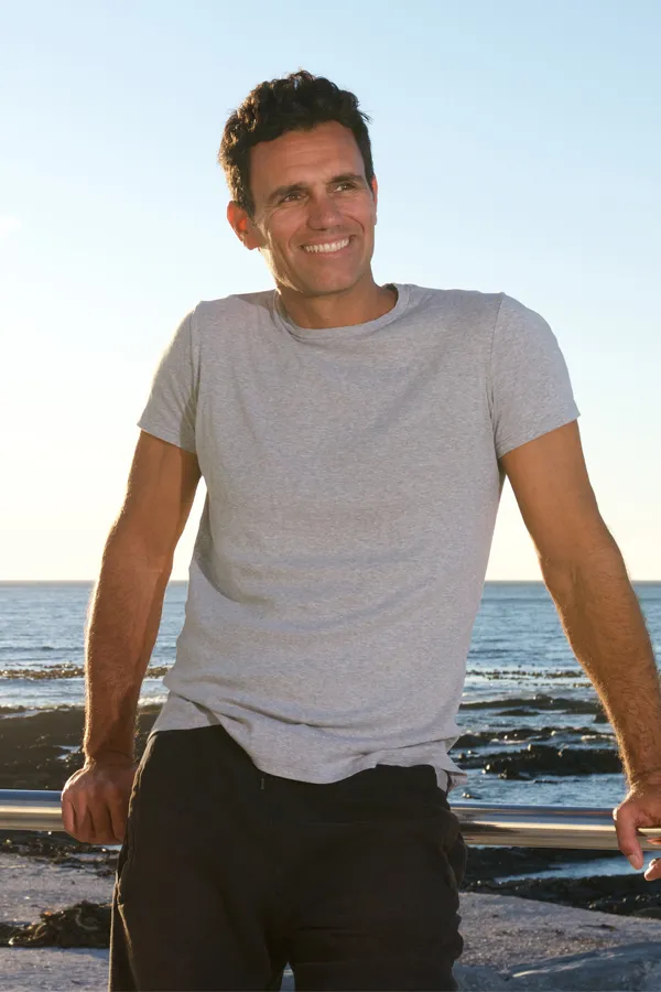 A fit middle-aged man stands by the ocean. Get laser body contouring treatment from Dr. Hadi Michael Rassael at Millennium Wellness in Bethesda-Chevy Chase.