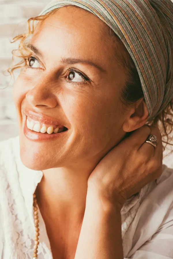 A middle-aged mixed-race woman with a bright, smooth face. Get a mini facelift from Dr. Hadi Michael Rassael at Millennium Wellness in Bethesda-Chevy Chase.